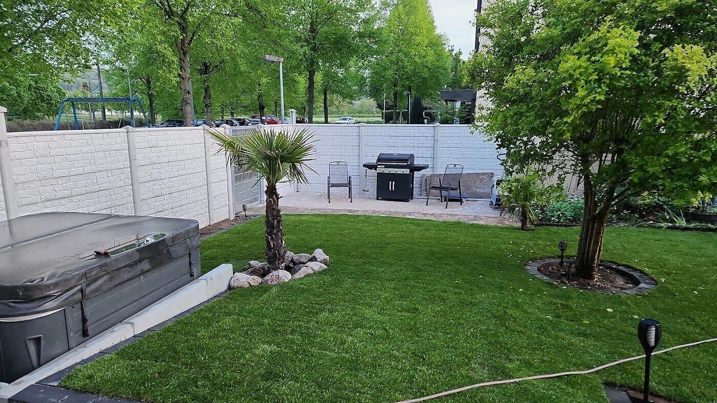 Gepflegter Rasen mit Terrasse und Sichtschutz
